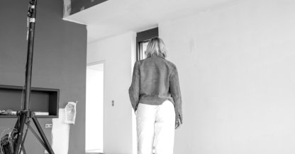 Nadine Rapp, architecte d'intérieur à Mulhouse, sur un chantier de rénovation en cours en Alsace, vue de dos dans un espace brut en travaux