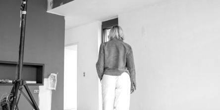 Nadine Rapp, architecte d'intérieur à Mulhouse, sur un chantier de rénovation en cours en Alsace, vue de dos dans un espace brut en travaux