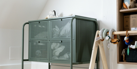 Chambre d'enfant sous combles avec commode en métal vert, étagères bois et tête d'éléphant en rotin, aménagement intérieur sur mesure à Mulhouse par Nadine Rapp