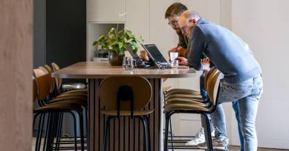 Zone de travail collaboratif avec îlot en bois et suspensions circulaires, aménagement de bureau sur mesure par Nadine Rapp architecte d'intérieur à Mulhouse