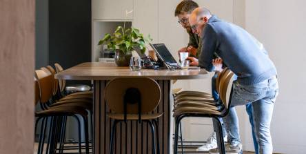 Zone de travail collaboratif avec îlot en bois et suspensions circulaires, aménagement de bureau sur mesure par Nadine Rapp architecte d'intérieur à Mulhouse