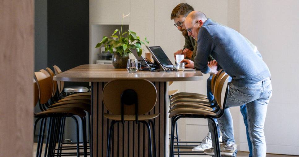 Zone de travail collaboratif avec îlot en bois et suspensions circulaires, aménagement de bureau sur mesure par Nadine Rapp architecte d'intérieur à Mulhouse
