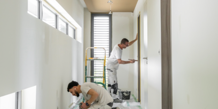 Artisans peintres au travail dans un couloir en cours de rénovation intérieure en Alsace, plafond doré et murs blancs, chantier coordonné par Nadine Rapp architecte d'intérieur à Mulhouse